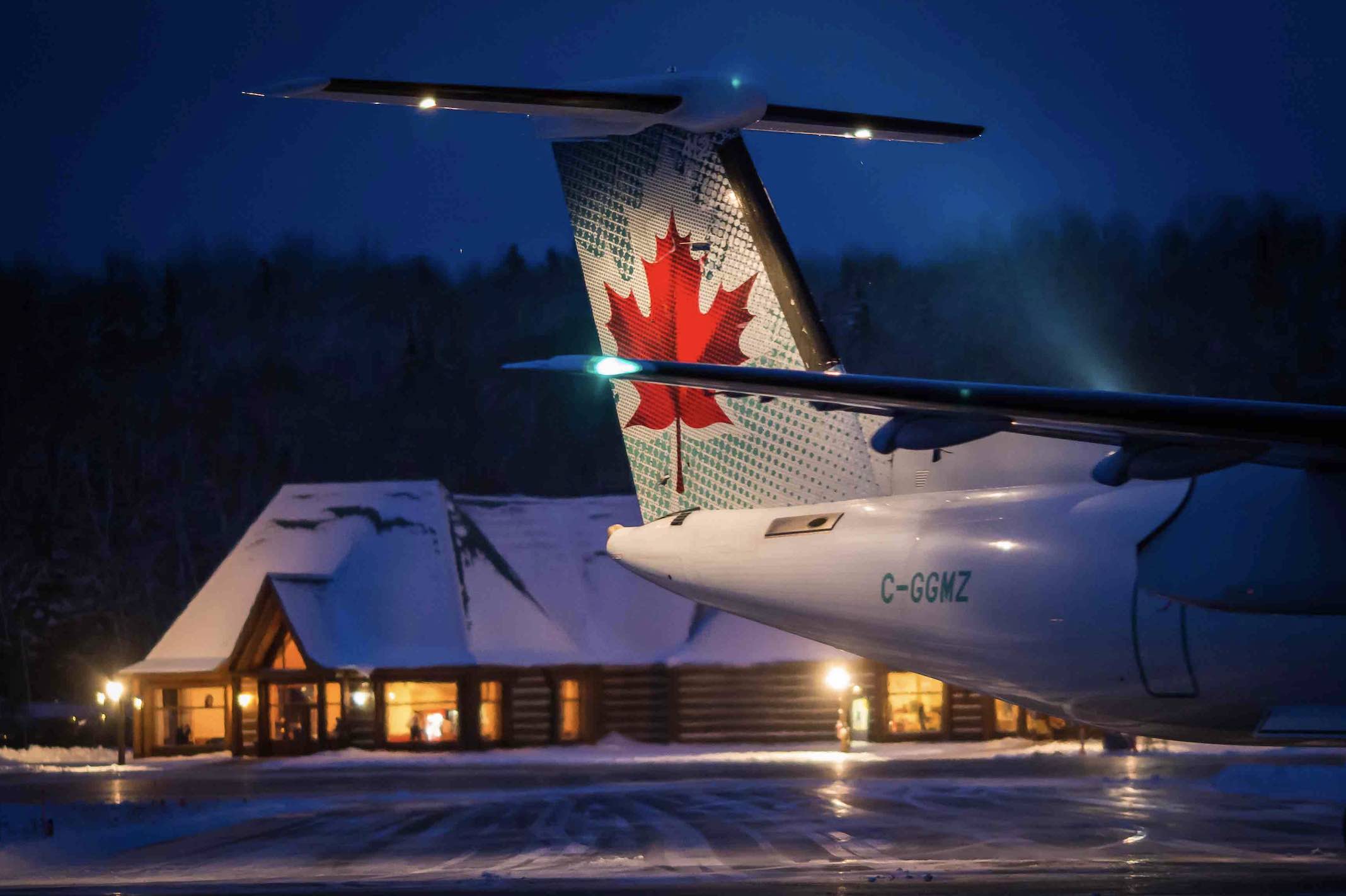 Air Canada jet sitting at airport in Mont-Tremblant at night