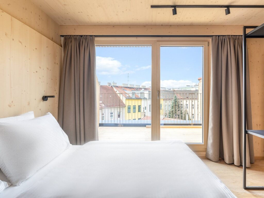 wood-rooms-apartments eco-friendly hotels in vienna wood panelled room with city view